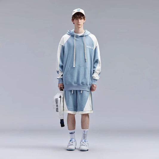Teen boy modeling light blue fake two-piece shorts with contrasting stitching.