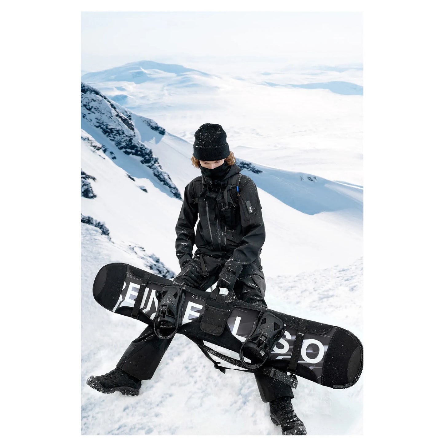 A man is sitting on the snow wearing The 0107 Ski Down Techwear Jacket in Black Color