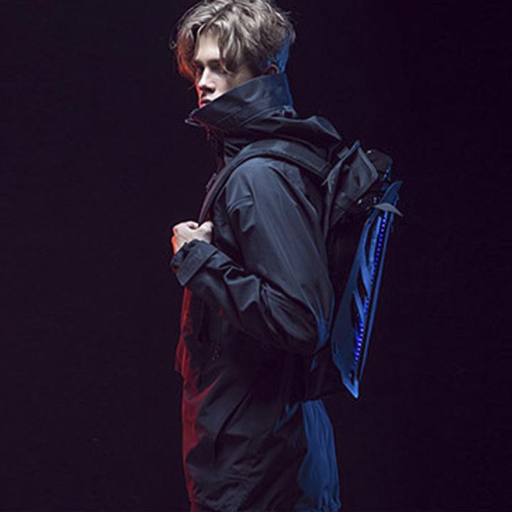 A man wearing the 3D Cyberpunk backpack and techwear jacket looking at the camera